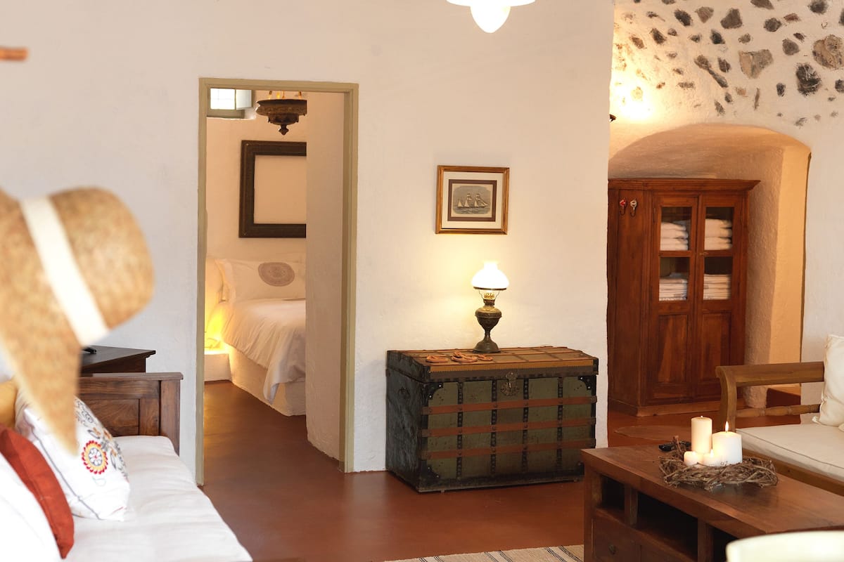 A cozy room with a bed, a wooden chest, a lamp, and a wardrobe.