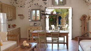 Una cocina rústica y acogedora con comedor, mobiliario de madera y techo de piedra.