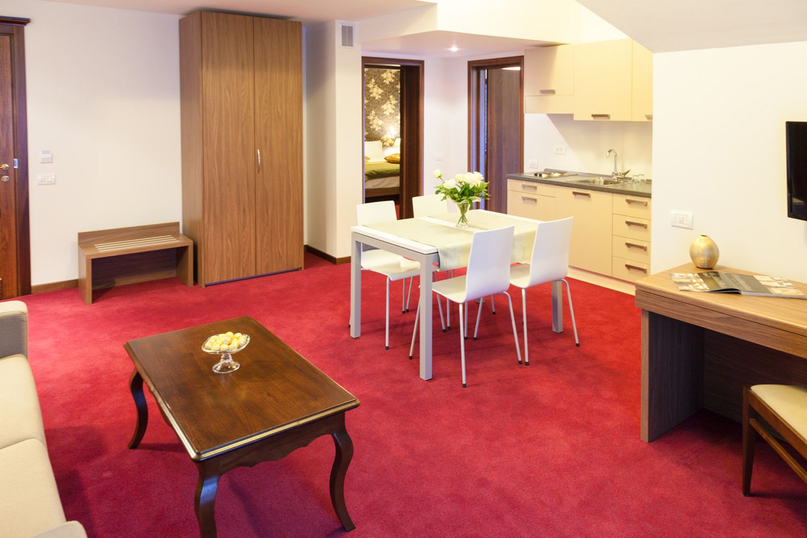Een compacte leefruimte met een eethoek, kitchenette en een klein zithoekje.