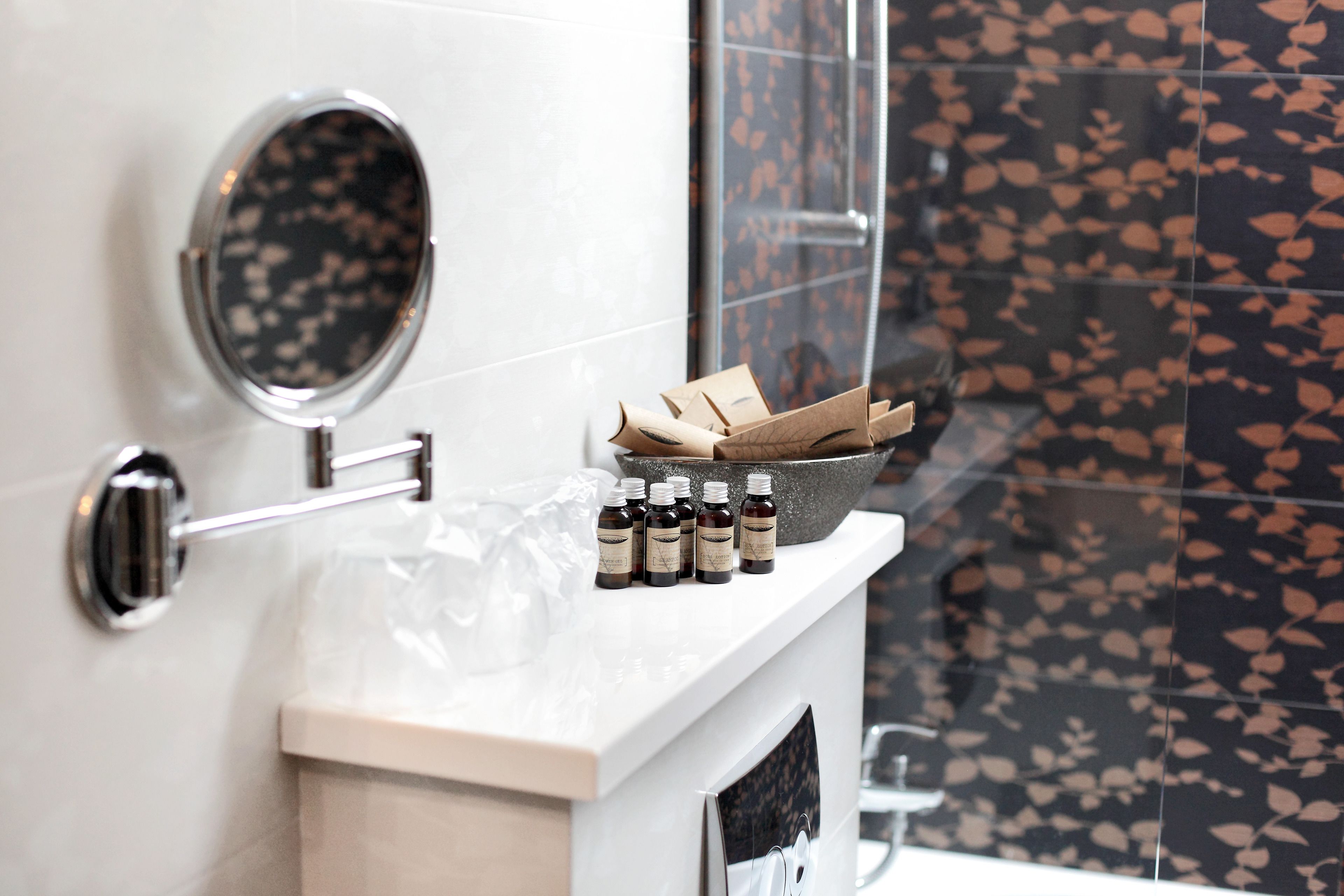 Une salle de bain avec un miroir, un porte-serviettes et une étagère contenant des bouteilles et des mouchoirs.