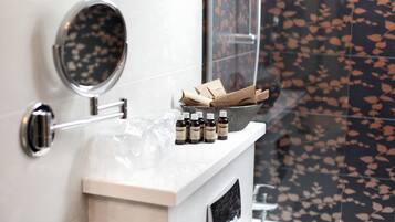 Une salle de bain avec un miroir, un porte-serviettes et une étagère contenant des bouteilles et des mouchoirs.