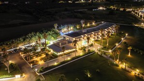 Un grand hôtel moderne doté de nombreuses chambres, d’une piscine et de chemins bien éclairés.