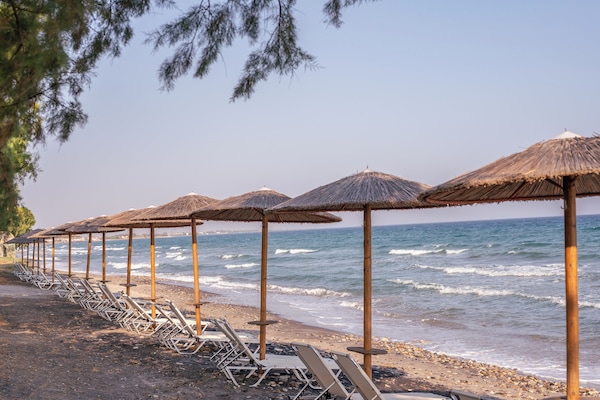 Na praia, espreguiçadeiras, guarda-sóis, bar na praia