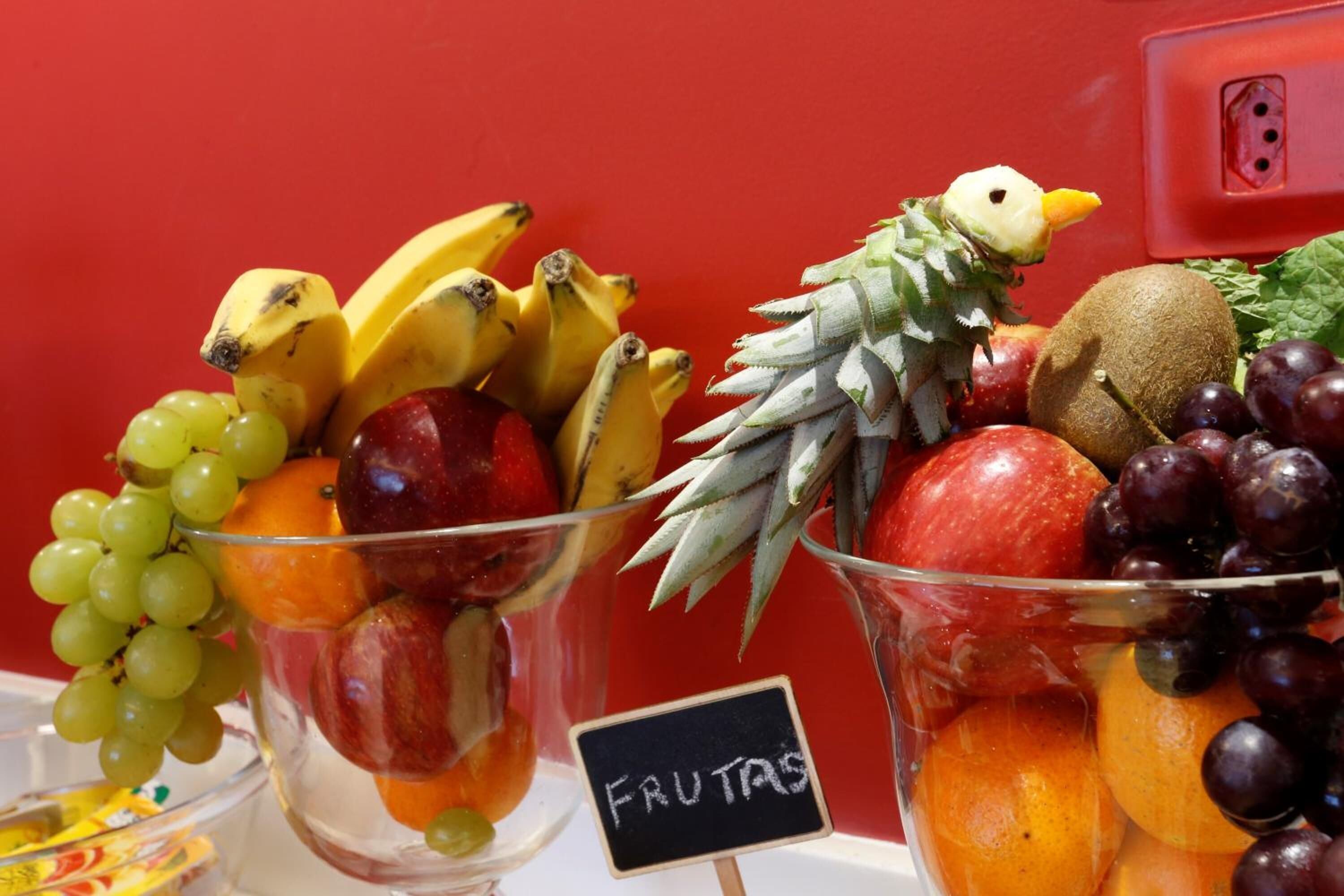 Dos recipientes de vidrio llenos de diversas frutas y un cartel que dice "FRUTAS".