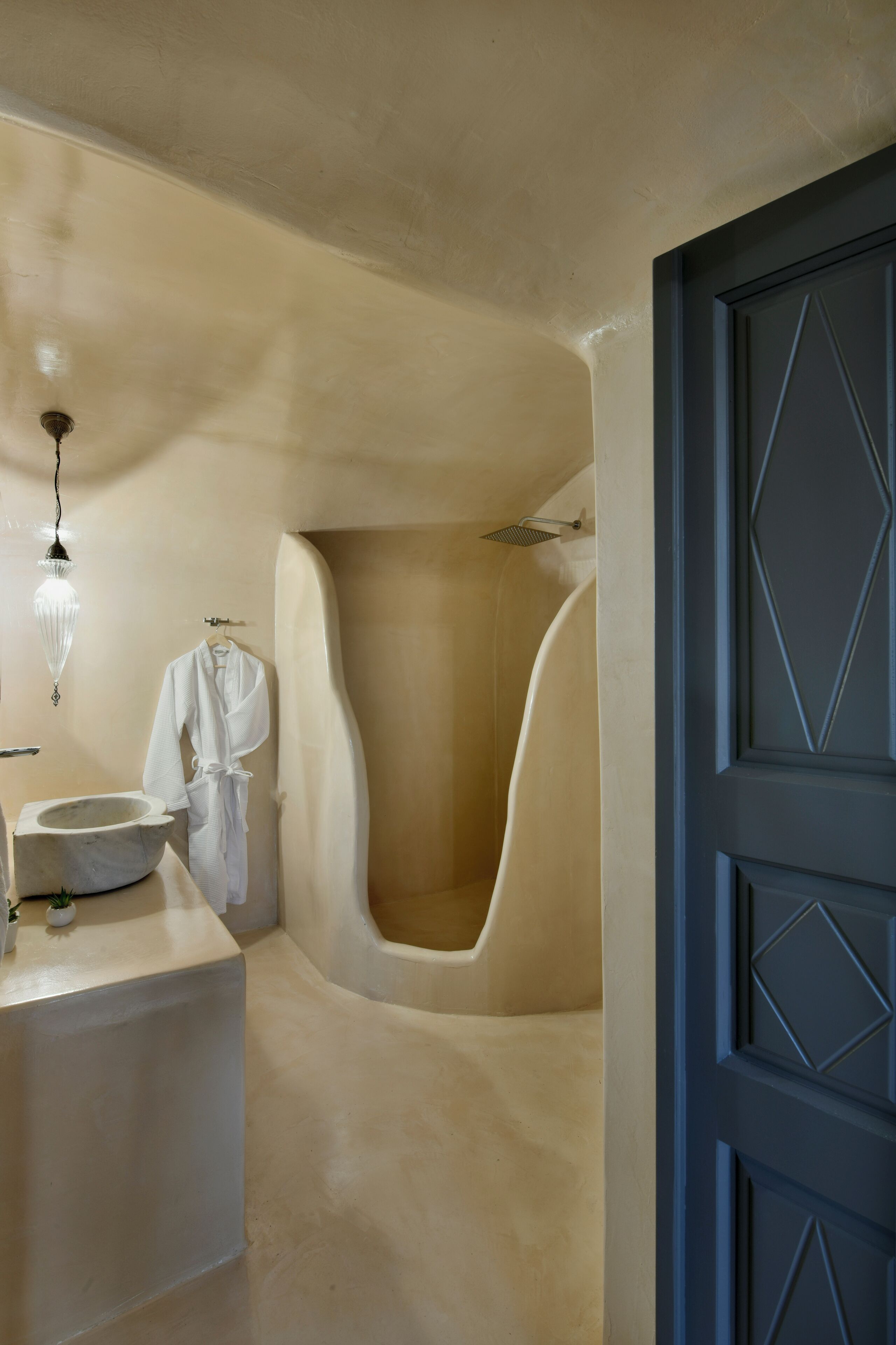 A bathroom with a bathtub, a sink, and a robe hanging on the wall.