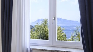 Una ventana con vista a una montaña y al mar.