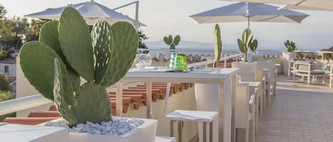 An outdoor dining area with tables, chairs, and umbrellas.