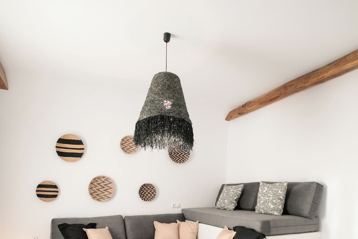 A modern living room with a grey sectional sofa, a round coffee table, and a hanging light fixture.