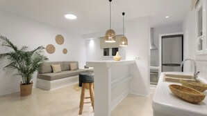 Una cocina moderna con una isla central, horno empotrado y refrigerador de acero inoxidable.