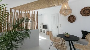 Un espacio moderno con zona de comedor, televisor y decoración en la pared.