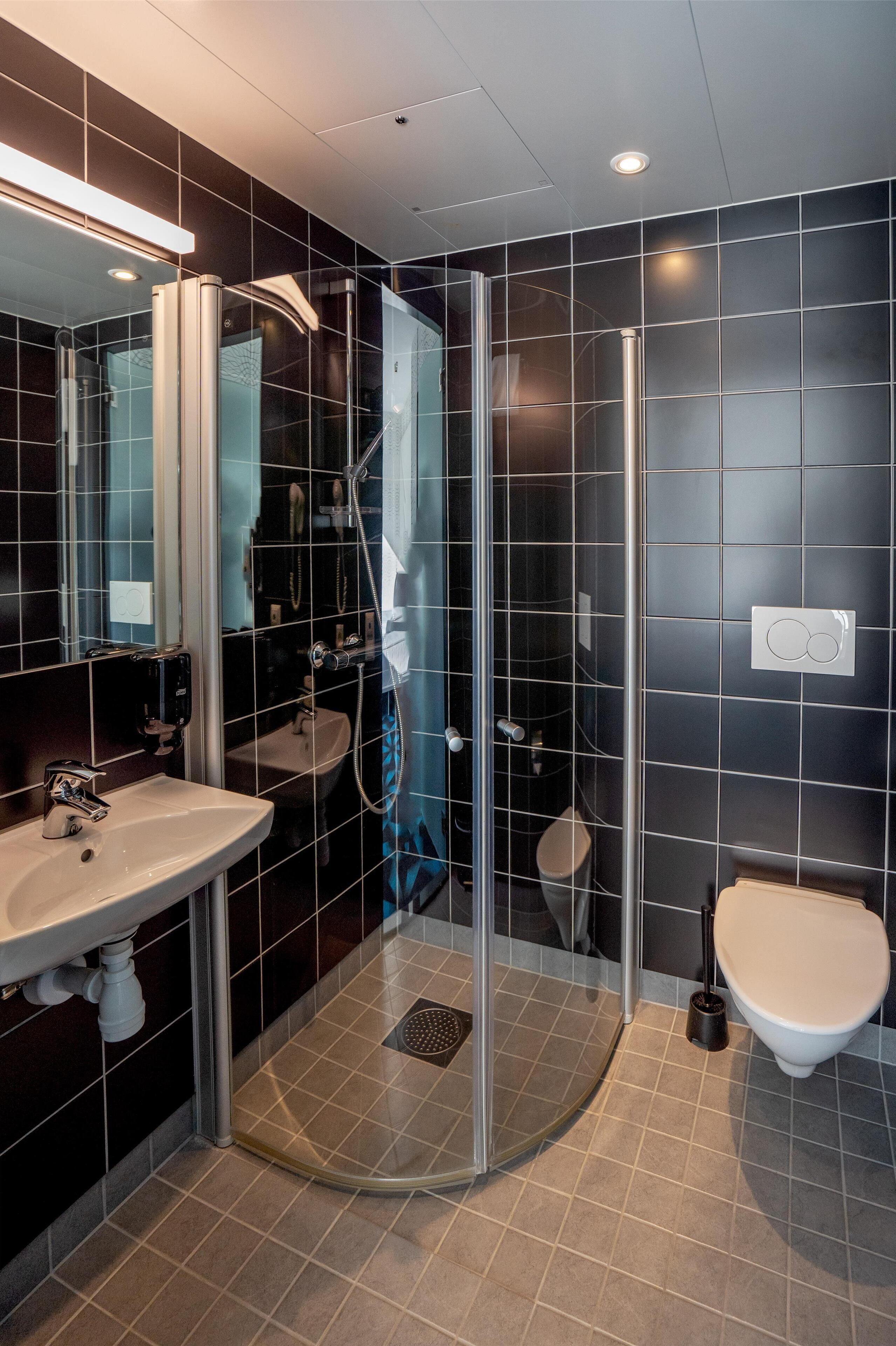 A modern bathroom with a glass-enclosed shower, a sink, and a toilet.