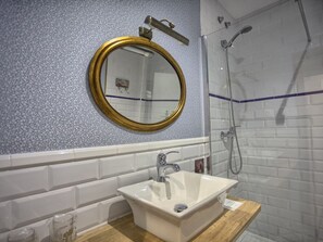 Driepersoonskamer | Badkamer | Een douche, gratis toiletartikelen, een haardroger, handdoeken