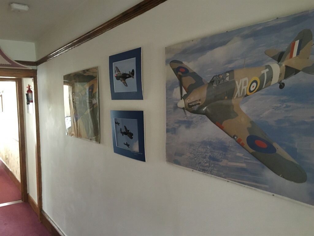 A hallway with framed pictures of aircraft on the wall.