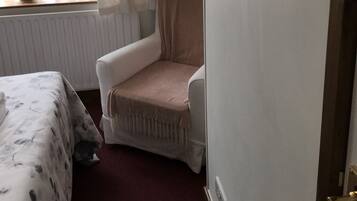 Ein Schlafzimmer mit einem Bett, einem Sessel und einer Heizung.