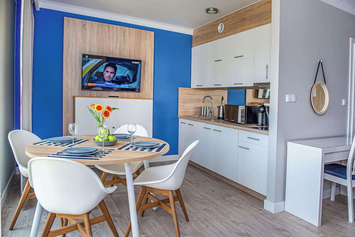 Eine moderne Küche mit weißen Schränken, einer Holz Arbeitsplatte und einer eingebauten Mikrowelle.