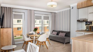 Eine moderne Wohnung mit Essbereich, Sofa und Küche.