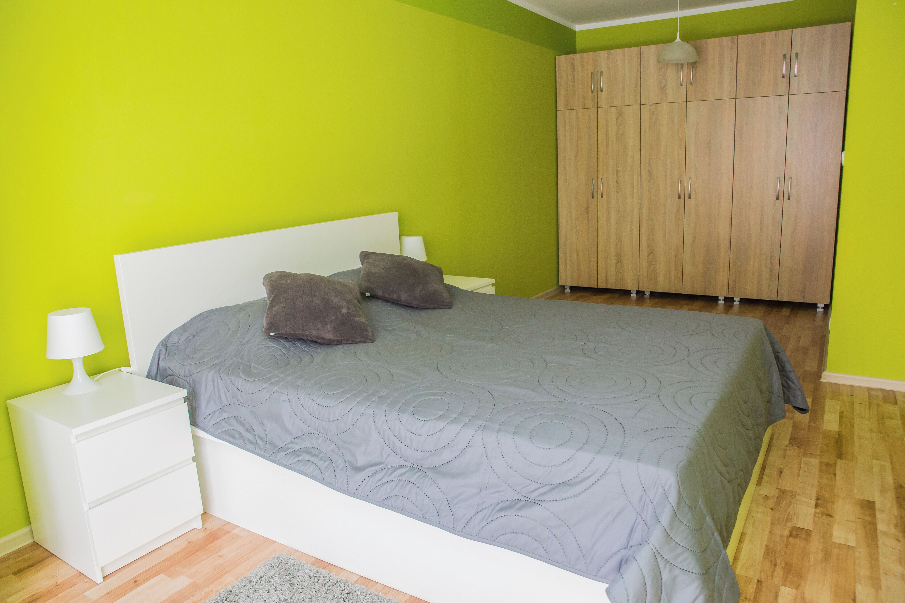 Ein Schlafzimmer mit einem Bett, Nachttischen, einer Lampe und einem Kleiderschrank.
