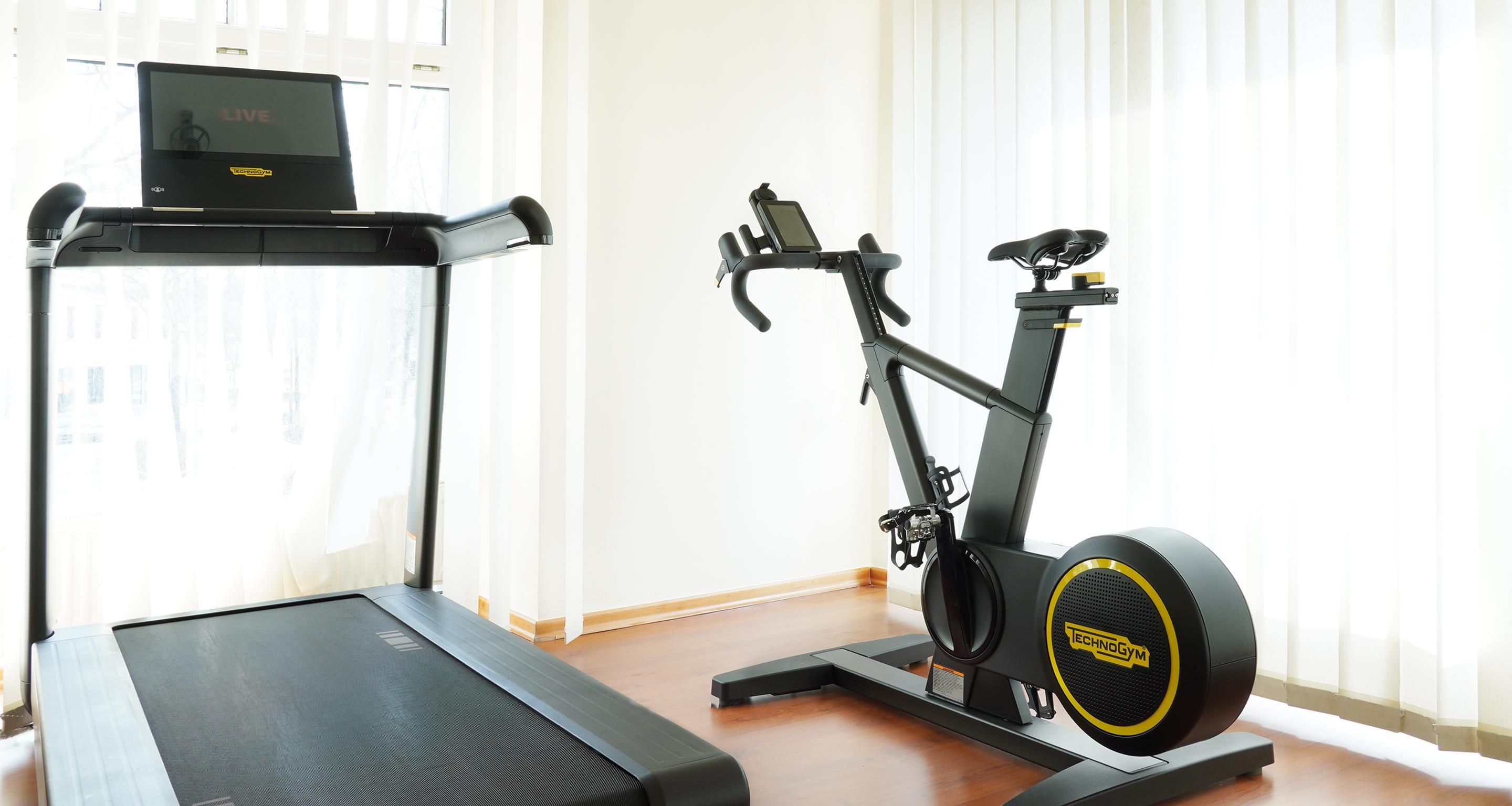 Un gimnasio en casa con cinta de correr y bicicleta estática.