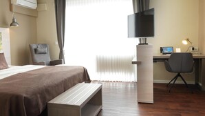 A hotel room with a bed, a desk with a computer, a chair, and a television. - Best Western Hotel St. Michael (Morbach)