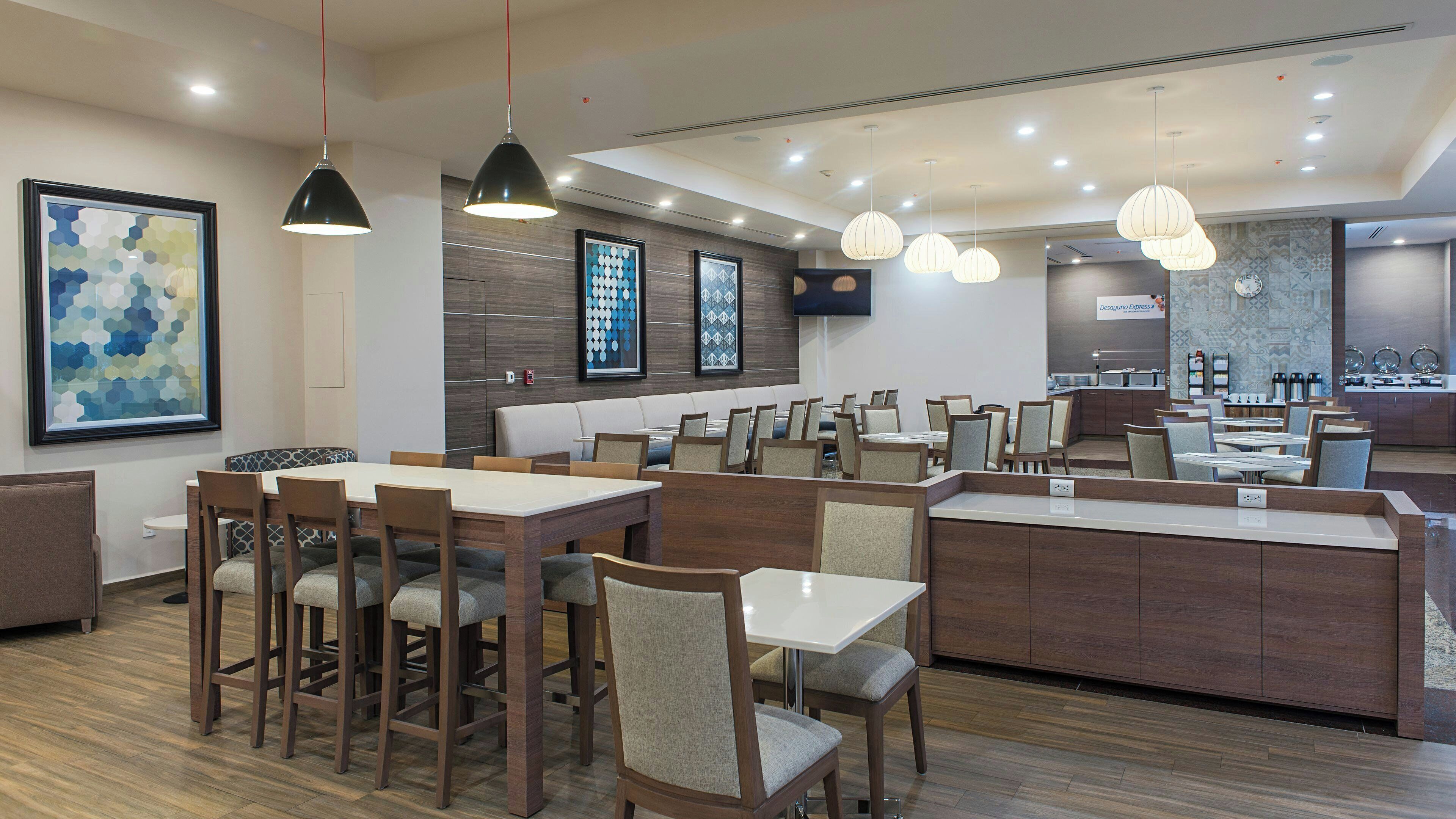 A modern restaurant with wooden furniture, pendant lighting, and a central island.