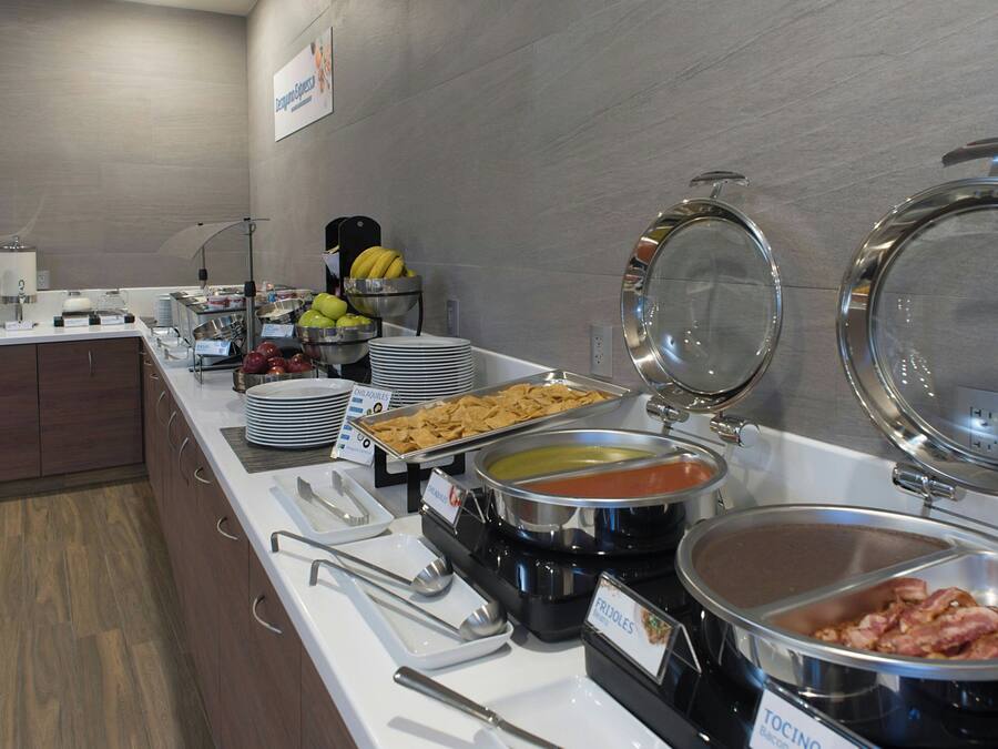 A buffet setup with various food items and serving utensils.