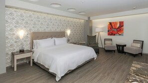 A hotel room with a large bed, a patterned wallpaper, a modern lamp, and a painting on the wall. - Holiday Inn Express Mexico - Toreo by IHG (Naucalpan)