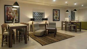 Un comedor moderno con una mesa, sillas y obras de arte en las paredes.