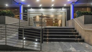A modern hotel entrance with a glass facade, a metal staircase, and a reception area. - Holiday Inn Express Mexico - Toreo by IHG (Naucalpan)