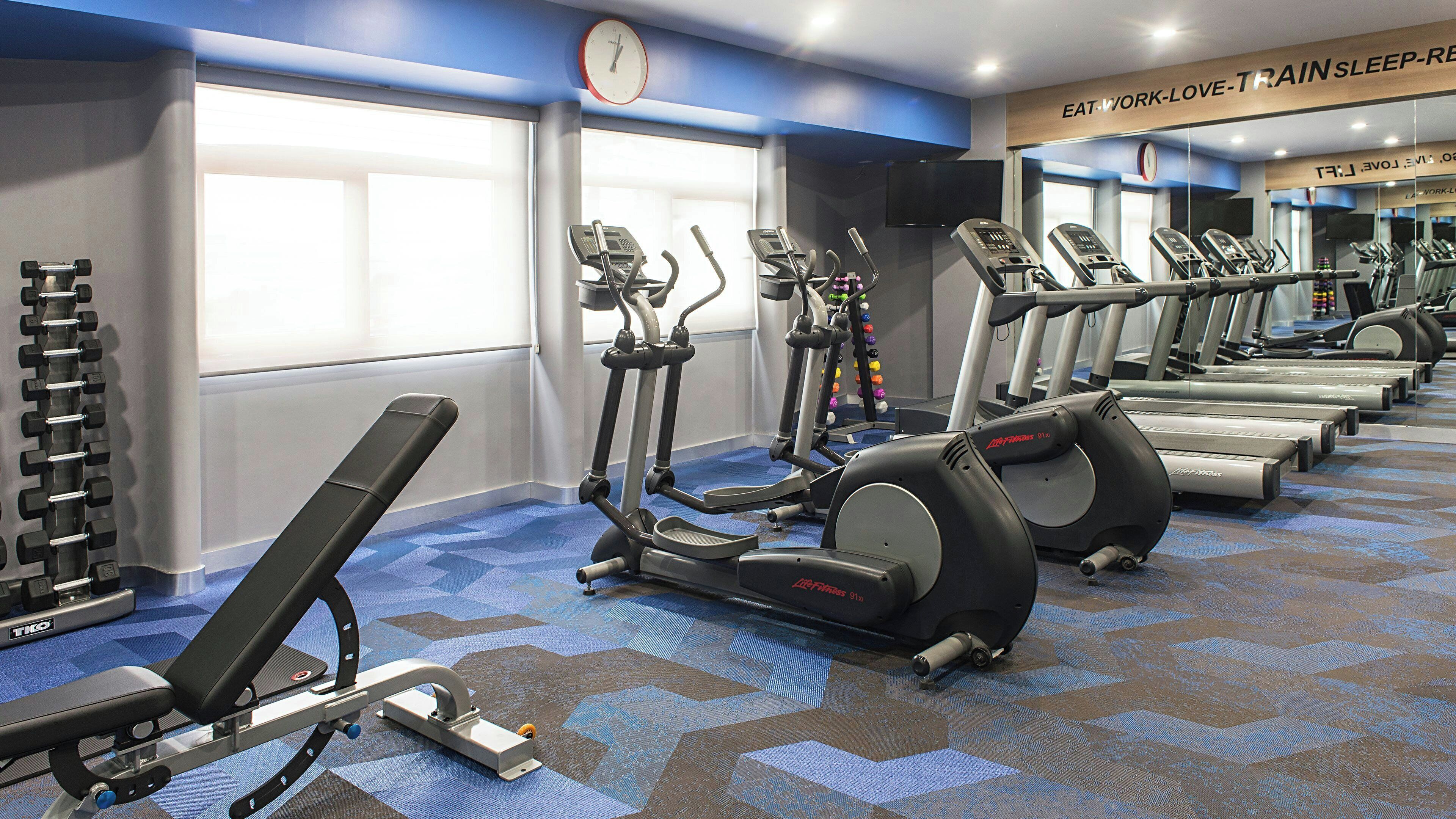 A gym with treadmills, ellipticals, and weight machines.