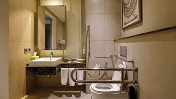 A modern bathroom with a large mirror, a sink, a toilet, and a shower area.