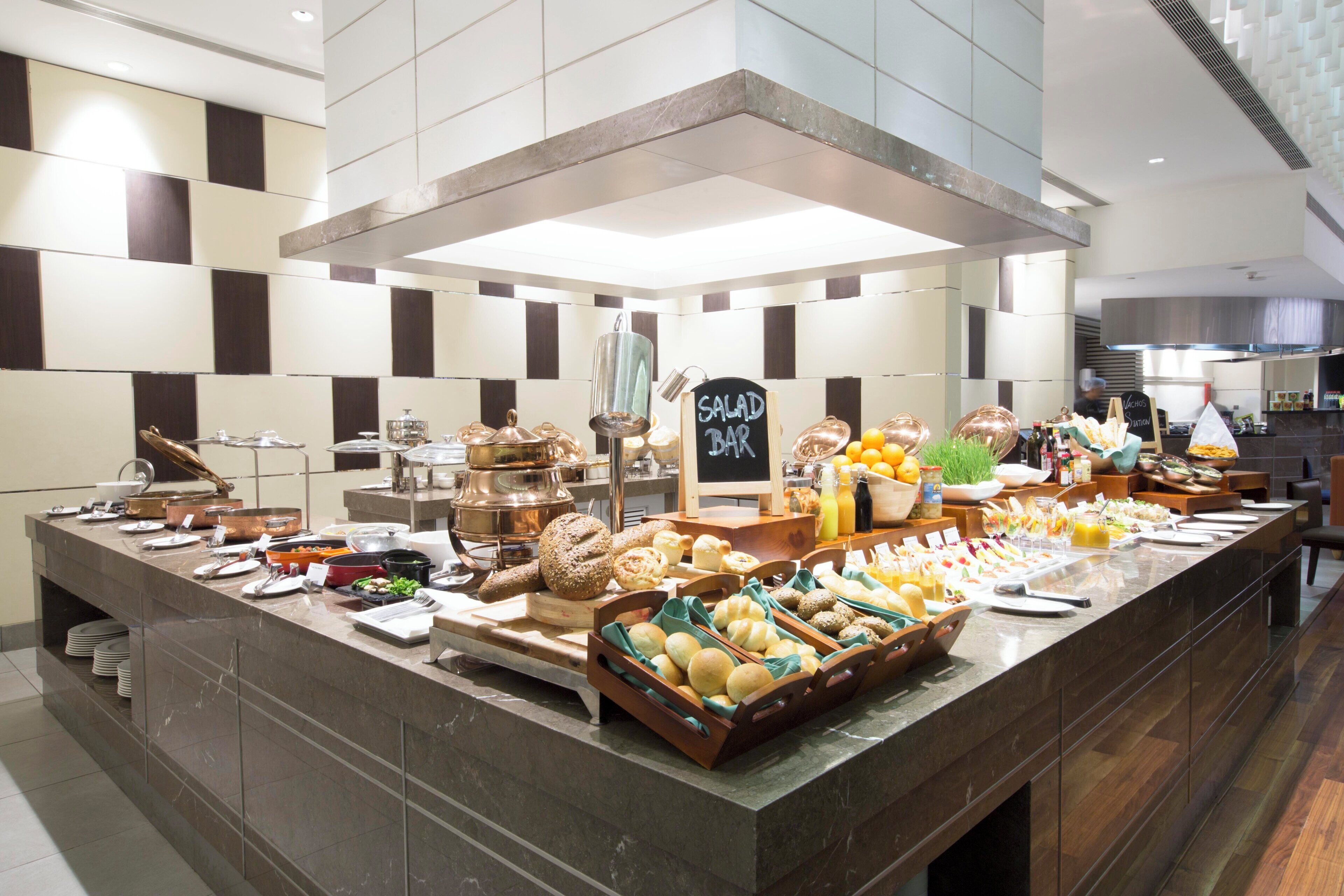 A buffet setup with various food items and a sign indicating a salad bar.