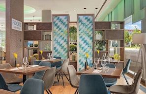 Interior de restaurante con varias mesas, sillas y un letrero que indica bar y bistró.