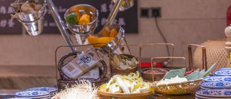 A buffet setup with various dishes and utensils.