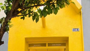 A yellow building with a sign reading "1361" and a door labeled "BISN MACHO". - Casa Canario La Americana (Guadalajara)