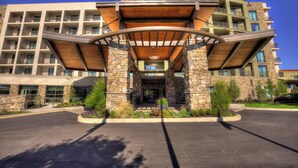 A multi-story hotel with a central entrance, stone pillars, and a wooden canopy. - Courtyard by Marriott Pigeon Forge (Pigeon Forge)
