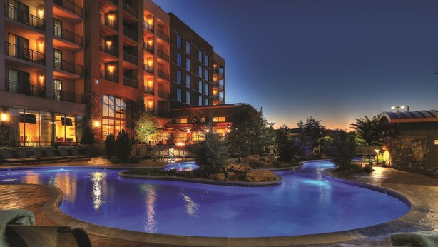 A hotel with a swimming pool, outdoor seating, and a well-lit building facade. - Courtyard by Marriott Pigeon Forge (Pigeon Forge)