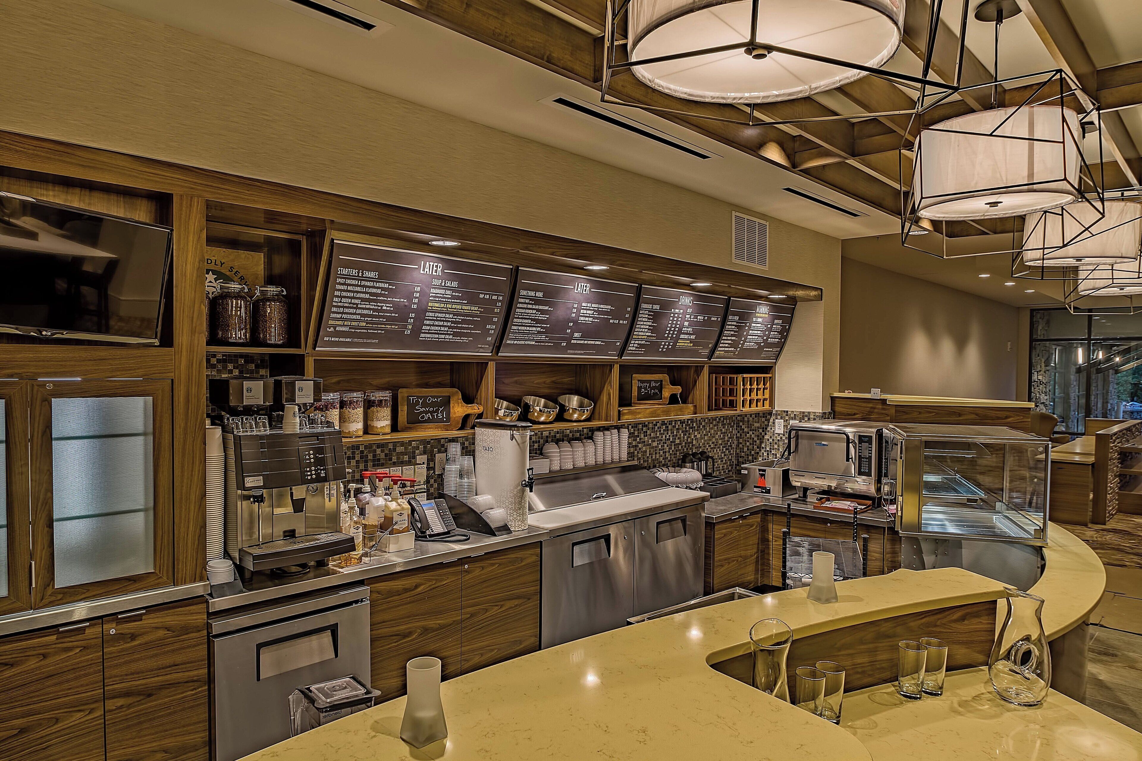 A modern coffee shop interior with a counter, menu boards, and various coffee-making equipment.