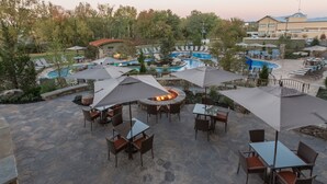 An outdoor patio area with stone flooring, tables, chairs, and umbrellas. - Courtyard by Marriott Pigeon Forge (Pigeon Forge)