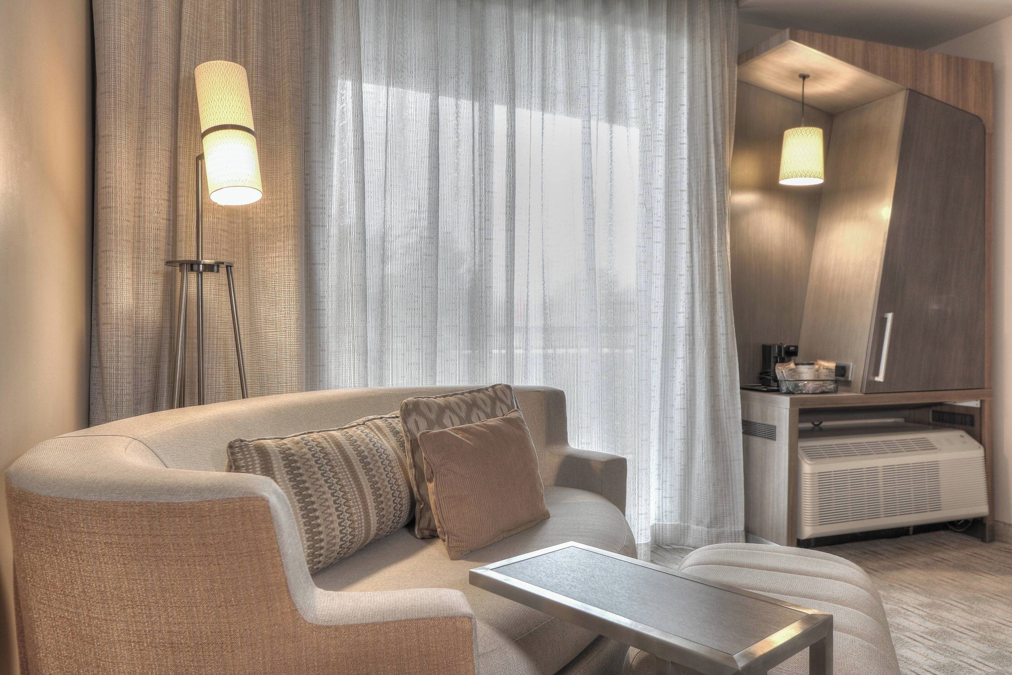 Een moderne woonkamer met een bank, een salontafel en een staande lamp.