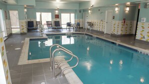 Une piscine intérieure à l’eau claire, dotée d’un poste de surveillance pour le sauveteur et d’un escalier pour y accéder.