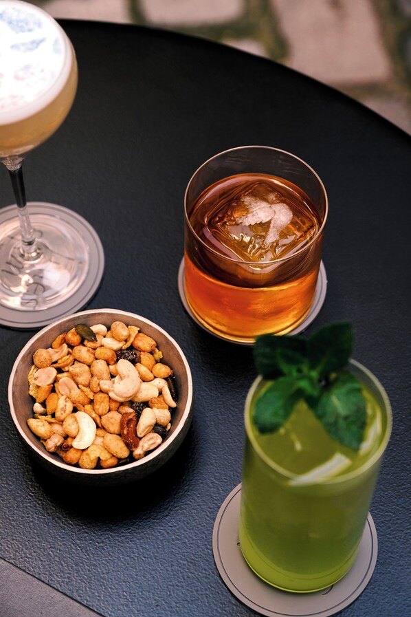 A table with three drinks and a bowl of nuts. - Hotel Jules & Jim (Paris)