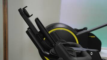 Una bicicleta estática con diseño negro y amarillo, un panel de control y un asiento.