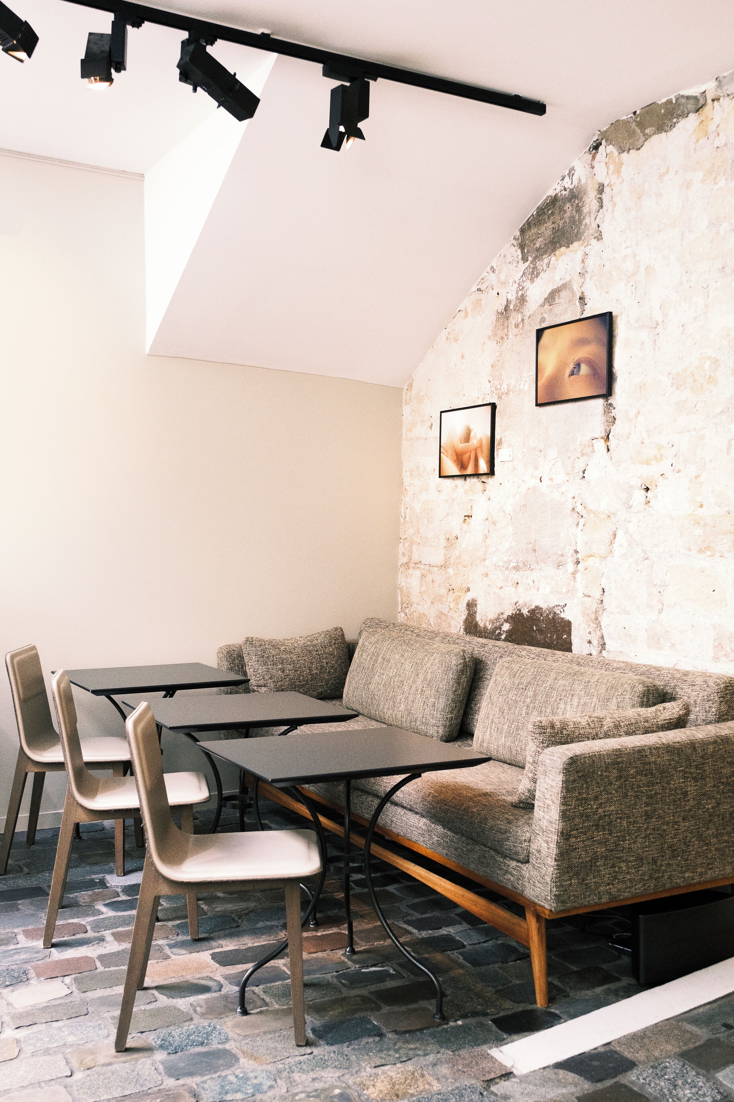 Un interior moderno con suelo de piedra, un sofá, una mesa y sillas.