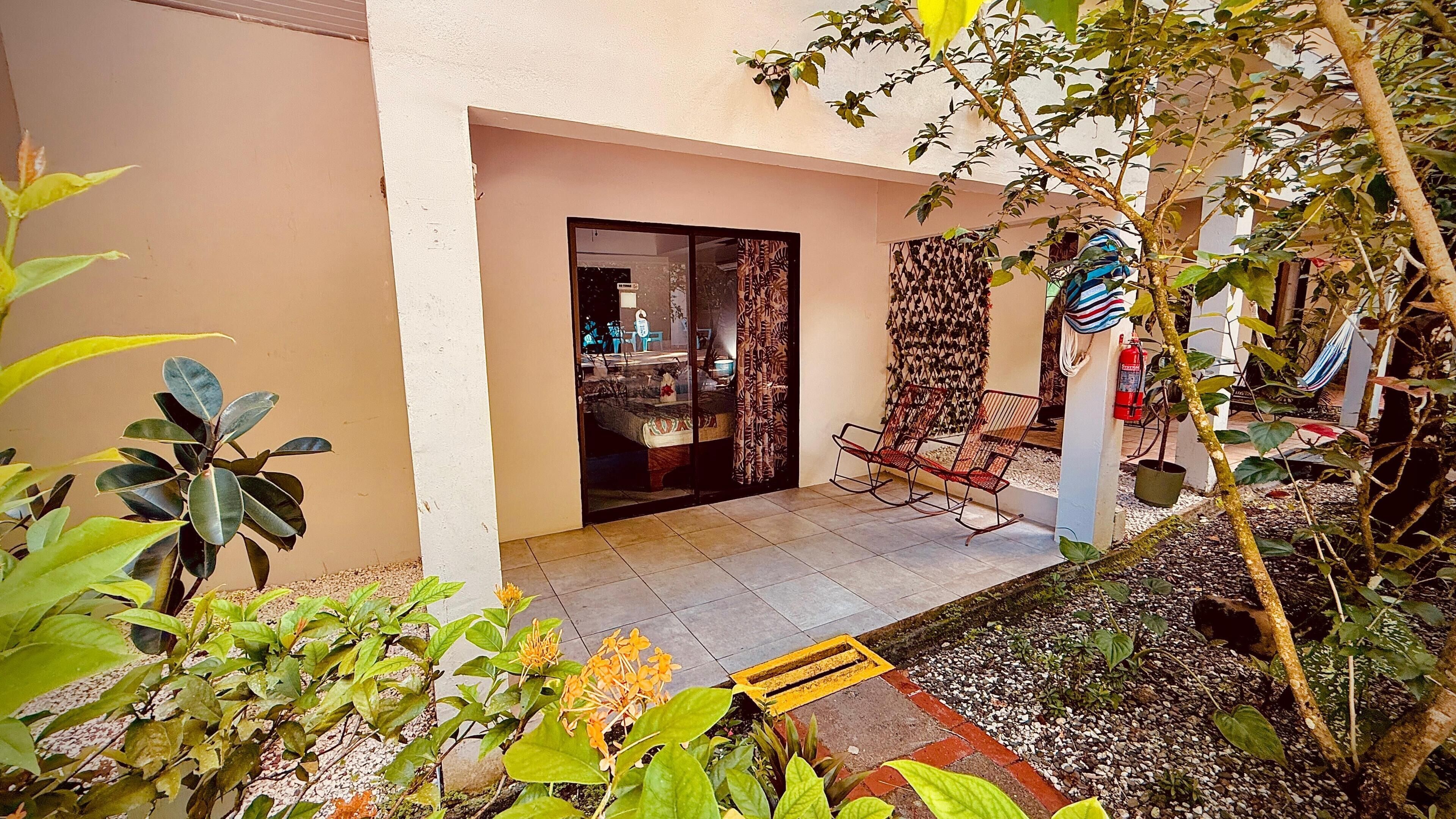 A patio with a seating area, a fire extinguisher, and a view into the interior of a building.