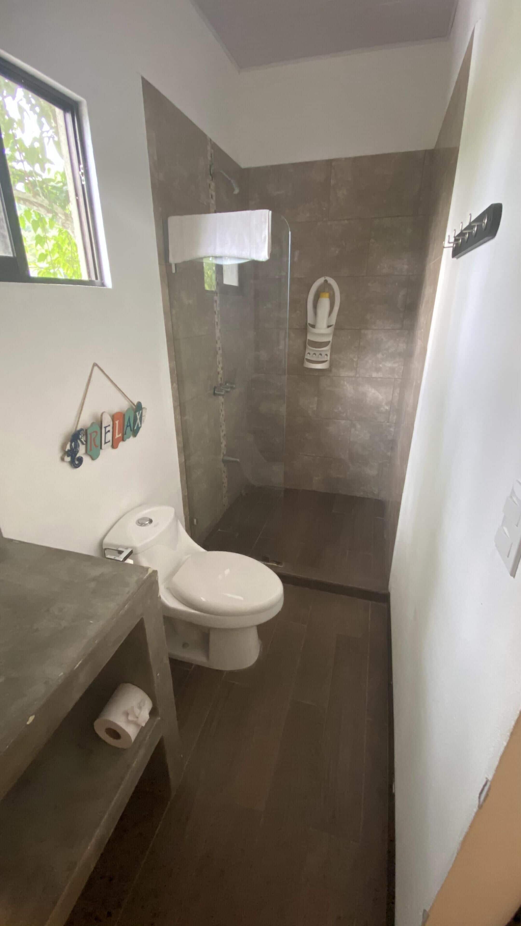 Un baño con inodoro, ducha y lavamanos.