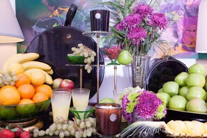 A table with fruits, a candle, and a vase of flowers.