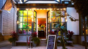 A restaurant with a signboard listing its hours of operation. - Zey Hotel (Greenport)