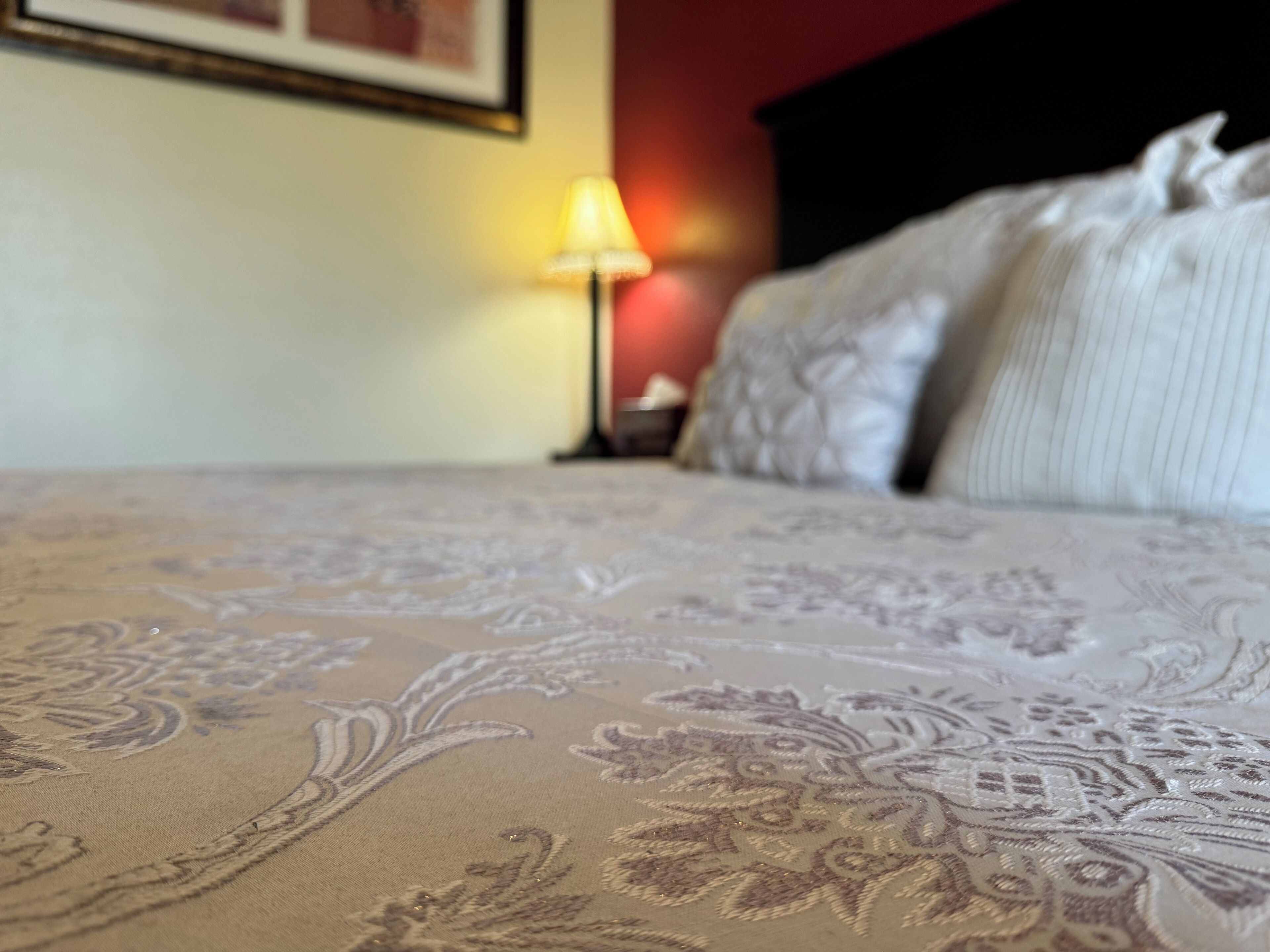A bed with a floral-patterned bedspread and a headboard.