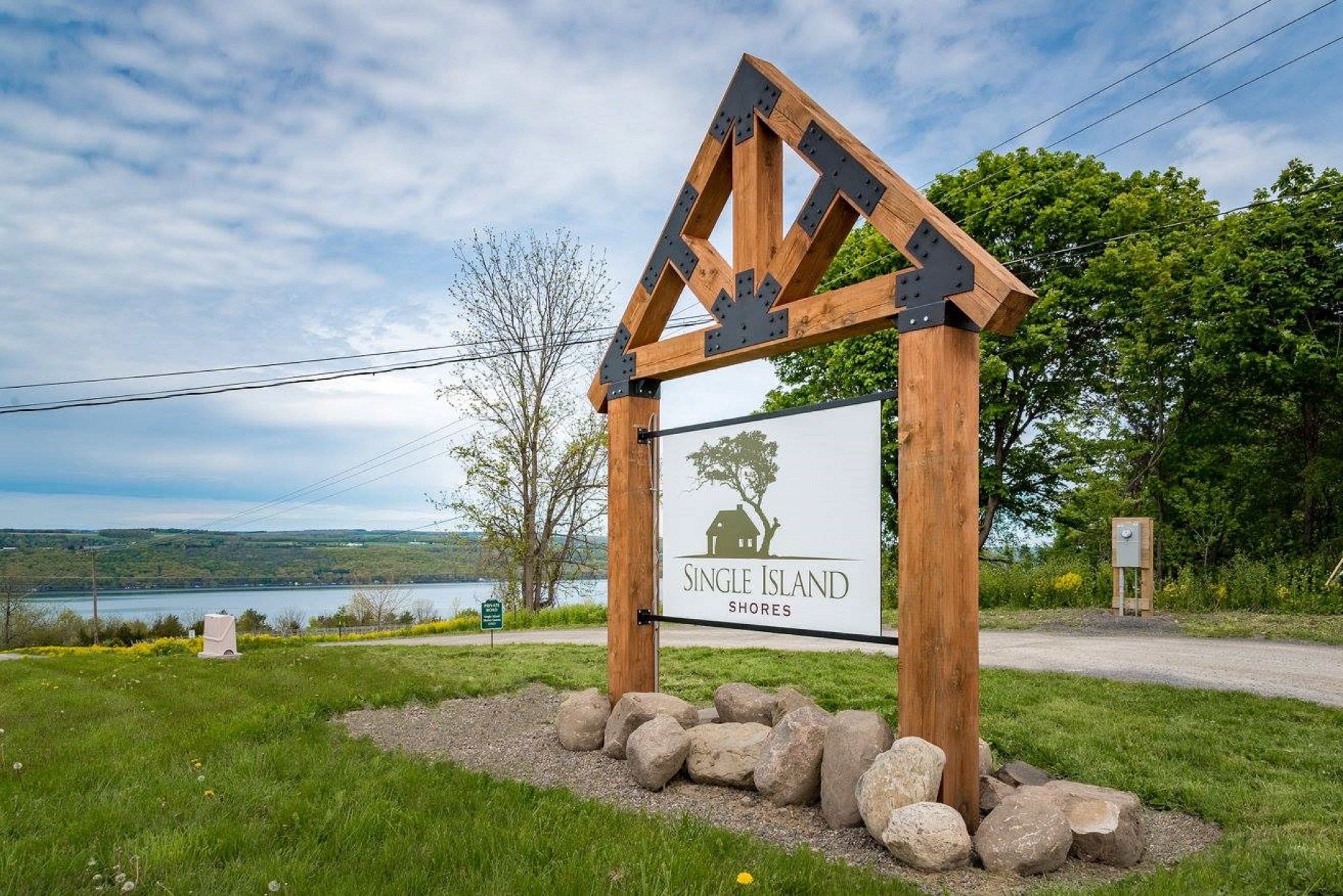 Un panneau en bois orné d’un logo représentant une maison et un arbre, sur lequel on peut lire : « Single Island Shores ».