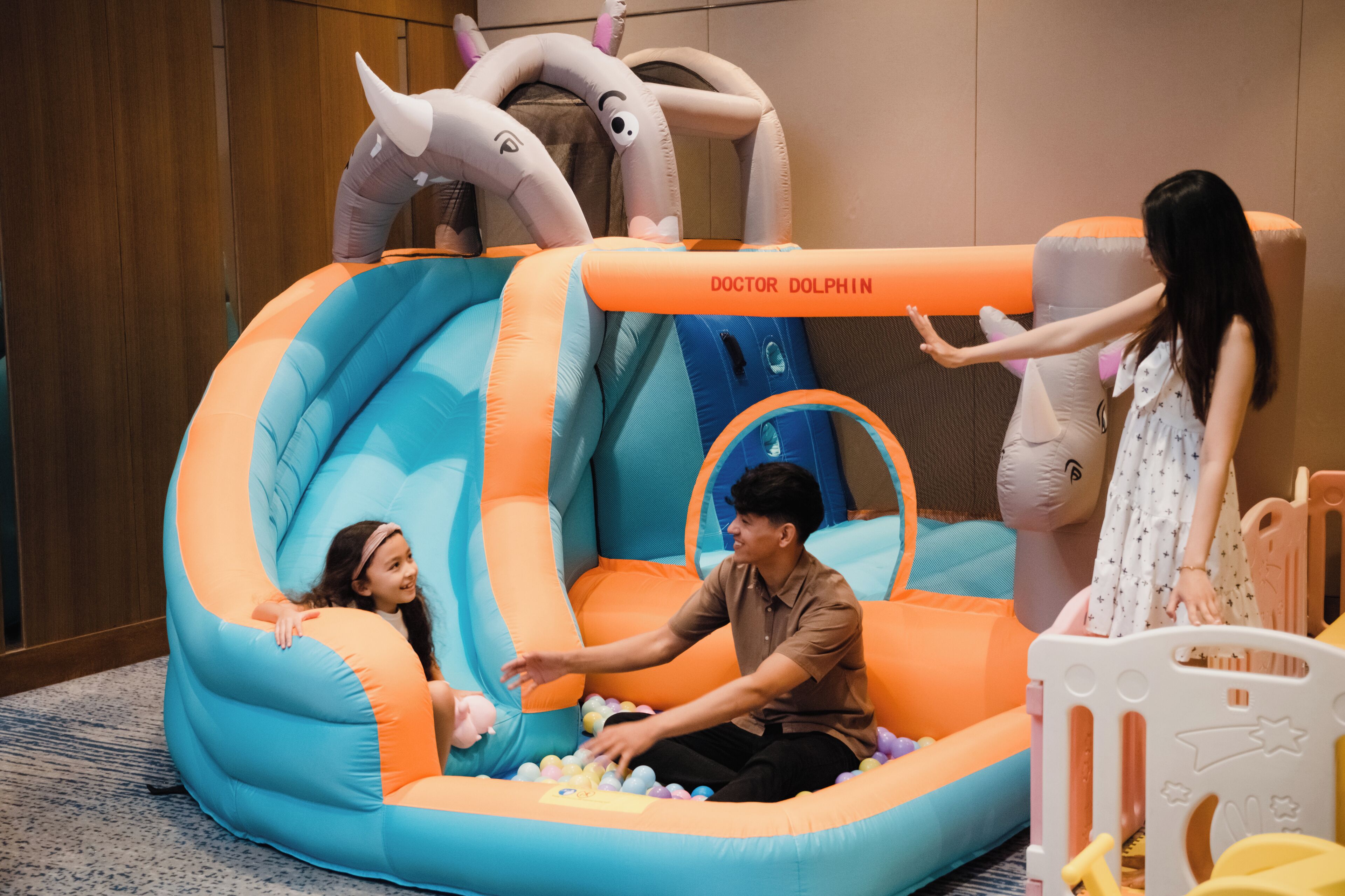An inflatable play area with a slide and a ball pit, labeled "DOCTOR DOLPHIN."